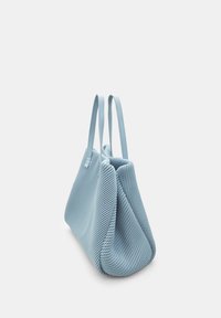 Borsa a mano di un blu chiaro con un motivo intrecciato testurizzato, due manici piatti e una forma triangolare unica che si assottiglia verso la base.