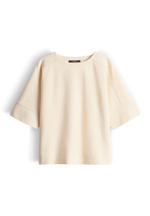 Lichtbeige top met korte mouwen, een ronde hals, een losse pasvorm en een zachte textuur. Voorzien van raglanmouwen en een gladde afwerking.