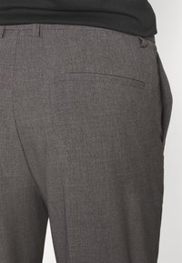 Grijze, op maat gemaakte broek met een gladde textuur, platte voorkant en een enkele achterzak, vervaardigd uit lichtgewicht stof.