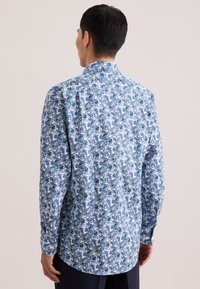 Langärmelig overhemd met een blauw-wit abstract patroon. Heeft een puntkraag, knoopmanchetten en een afgeronde zoom. Gemaakt van lichtgewicht stof.