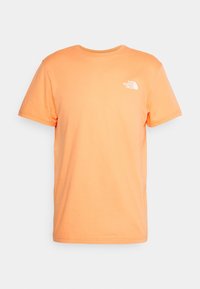 Short-sleeve orange T-shirt with crew neck and small white "The North Face" logo on the left chest against a plain background.