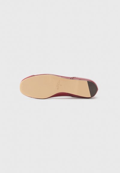 Red leather shoe sole with a smooth beige rubber bottom. Features a slight heel and is marked with brand name and size.
