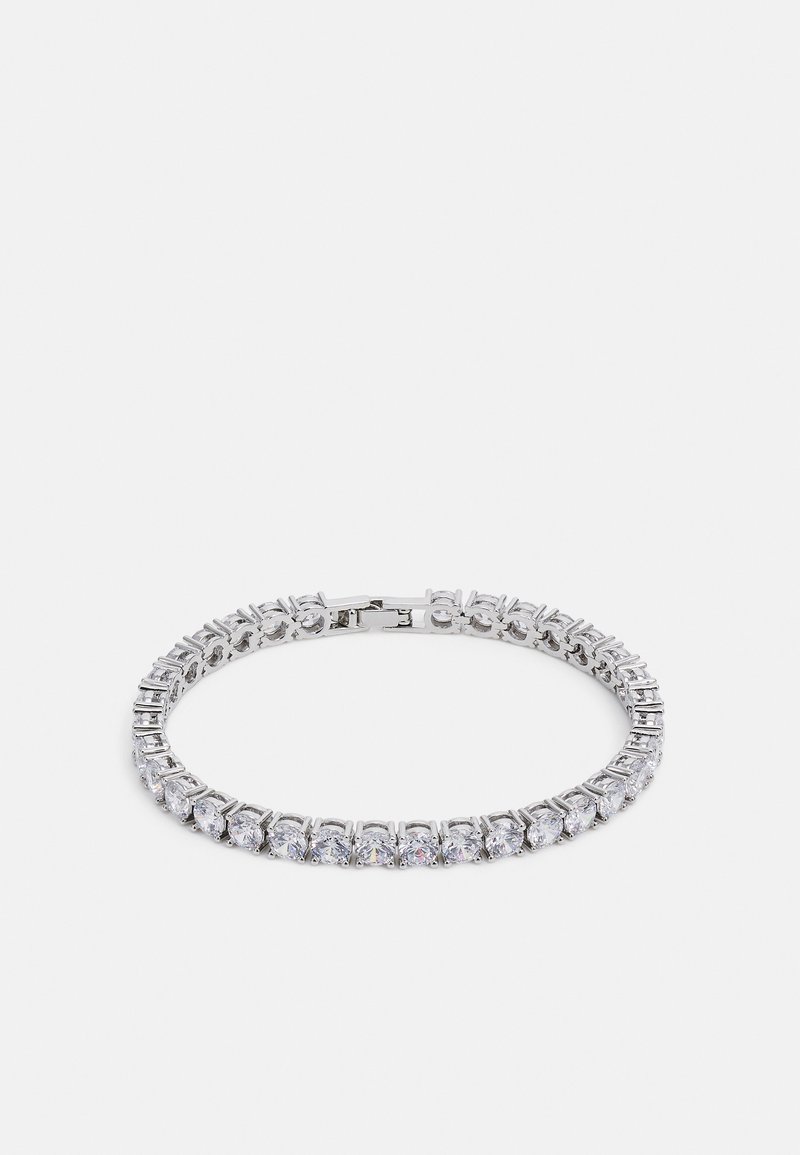 Sidabrinis apyrankė, puošta keliais skaidriais, apvaliais ir kvadratiniais kristalais, išdėstytais simetriškame rašte, su užsegimu.