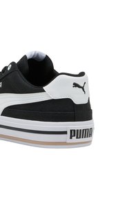Sneaker in bianco e nero con tomaia in tessuto testurizzato, dettagli in morbida pelle e suola in gomma con un audace logo "PUMA".
