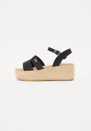 Schwarze Plateausandalen mit zwei breiten Riemen, verstellbarem Knöchelriemen und einem midsole aus einem gewebten, juteähnlichen Material. Strukturiertes Gummiaußensohle.