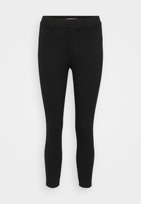 Zwarte leggings gemaakt van rekbare stof, met een aansluitend ontwerp, knoopsluiting en decoratieve stiksels aan de zijkanten.
