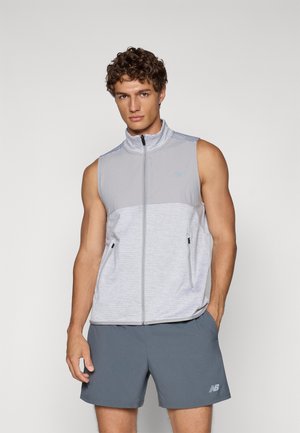 Sleeveless, light gray vest with a high collar, zip closure, and side pockets; features a textured fabric and subtle branding accents.