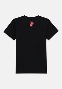T-shirt de algodão preto com um gráfico vermelho de uma boca aberta nas costas, com o texto "Santa Cruz" por baixo. Mangas curtas, design de golas redondas.