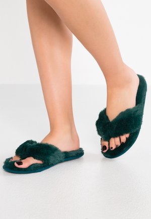 Grønne fluffy skydesandaler med en blød, pudderagtig tekstur og en tyk, komfortabel sål. Har to remme henover toppen.