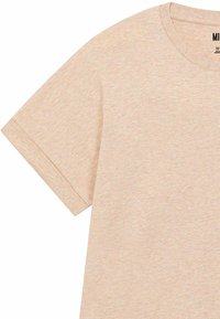 T-shirt beige chiaro con scollatura rotonda e maniche corte, che mostra un tessuto lavorato con leggere variazioni di colore.