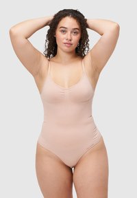 Jeden jednoczęściowy strój kąpielowy w jasnym kolorze brzoskwiniowym z cienkimi, regulowanymi ramiączkami, marszczeniem przy biuście oraz gładkim, elastycznym materiałem. Wysokie wycięcie na nogi.