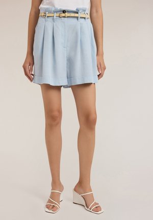 Light blue, pleated shorts with a waistband featuring a cream belt. The fabric appears smooth, with a relaxed fit and cuffed hems.