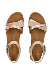 Beige sandály s křížovými pásky ve třpytivě růžovém zlatě. Obsahují zapínání na přezku, texturovanou hnědou stélku a plochou podrážku.