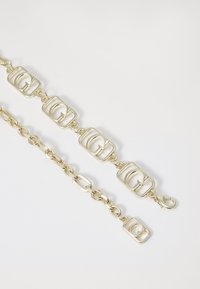 Bracciale d'oro con link rettangolari e incisa la "G" al centro, alternati a segmenti di catena ovale e chiusura a moschettone.