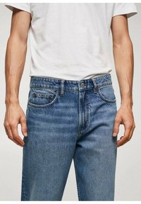 Pantalones vaqueros de mezclilla azul claro con corte recto, que presentan un diseño de cinco bolsillos, cierre de botón metálico y un desvanecimiento sutil en la tela.