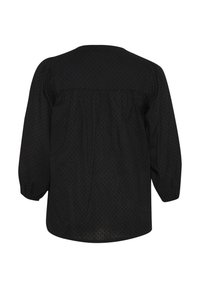 Blusa nera con un motivo a pois testurizzato, scollatura tonda e maniche a sbuffo. Vestibilità ampia con dettagli arricciati sul retro.