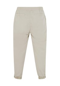 Světle béžové kalhoty s elastickým pasem, zúžené u kotníků, s dvěma zadními kapsami a hladkou, lehkou tkaninou.