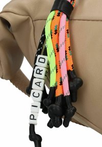Beige leather handbag with colorful braided pull tabs in black, green, orange, pink, and decorative plastic beads spelling "PICARD."