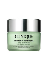 Grön glasburk med Clinique Redness Solutions dagkräm för lindring, med ett silverfärgat skruvkapsyl och svart text som beskriver produkten.