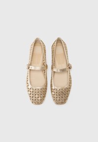 Pantofi flats Mary Jane aurii din piele perforată, cu vârful pătrat și o curea peste mijlocul piciorului. Captuseală interioară netedă, bej.