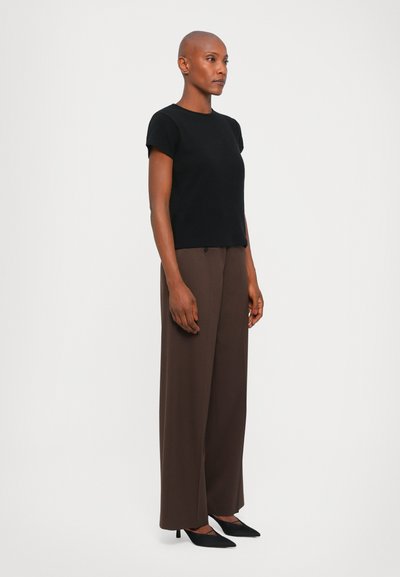 Black short-sleeve sweater paired with brown wide-leg trousers and black pointed-toe heels, featuring a simple and clean design.