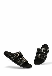 Chanclas negras con doble tira ancha adornada con ojales y hebillas plateadas. Material de ante suave con un diseño de suela plana.