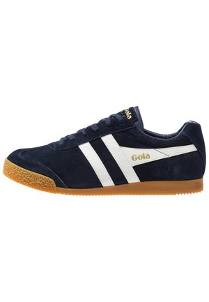 Sneakers Gola con tomaia in suede blu navy, strisce bianche e logo dorato; suola in gomma con battistrada testurizzato per una buona aderenza.