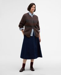 Cardigan en tricot côtelé marron avec une fermeture éclair, porté par-dessus une chemise à carreaux bleu clair, associé à une jupe en denim bleu marine et des chaussettes bordeaux.
