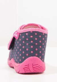 Chaussure enfant bleu marine à pois roses, avec semelle et bordure roses, vue de dos avec une bride Velcro latérale.