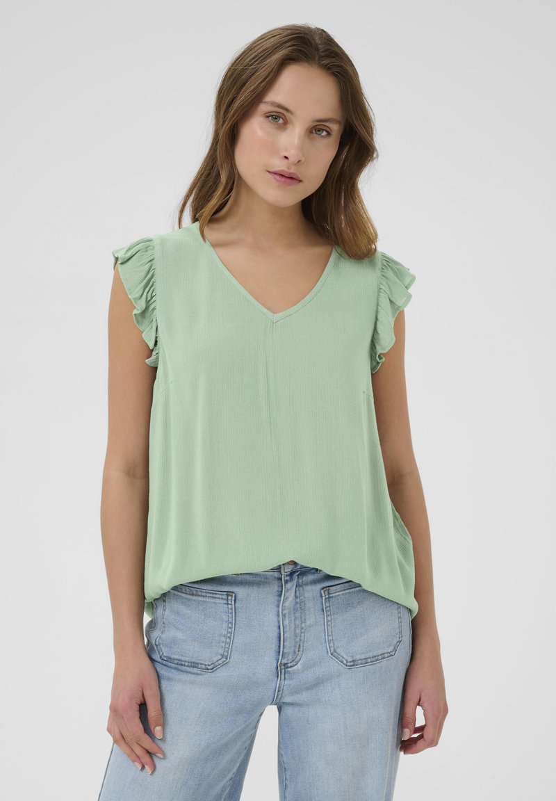 Haut sans manches vert menthe avec un décolleté en V, présentant des épaules froncées et une coupe décontractée. Tissu doux et léger avec une texture subtile.