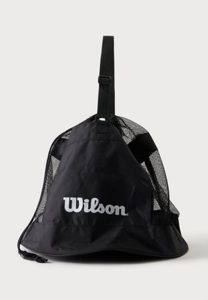 Bolsa deportiva de malla negra Wilson con correa ajustable y cierre de cordón sobre fondo blanco.