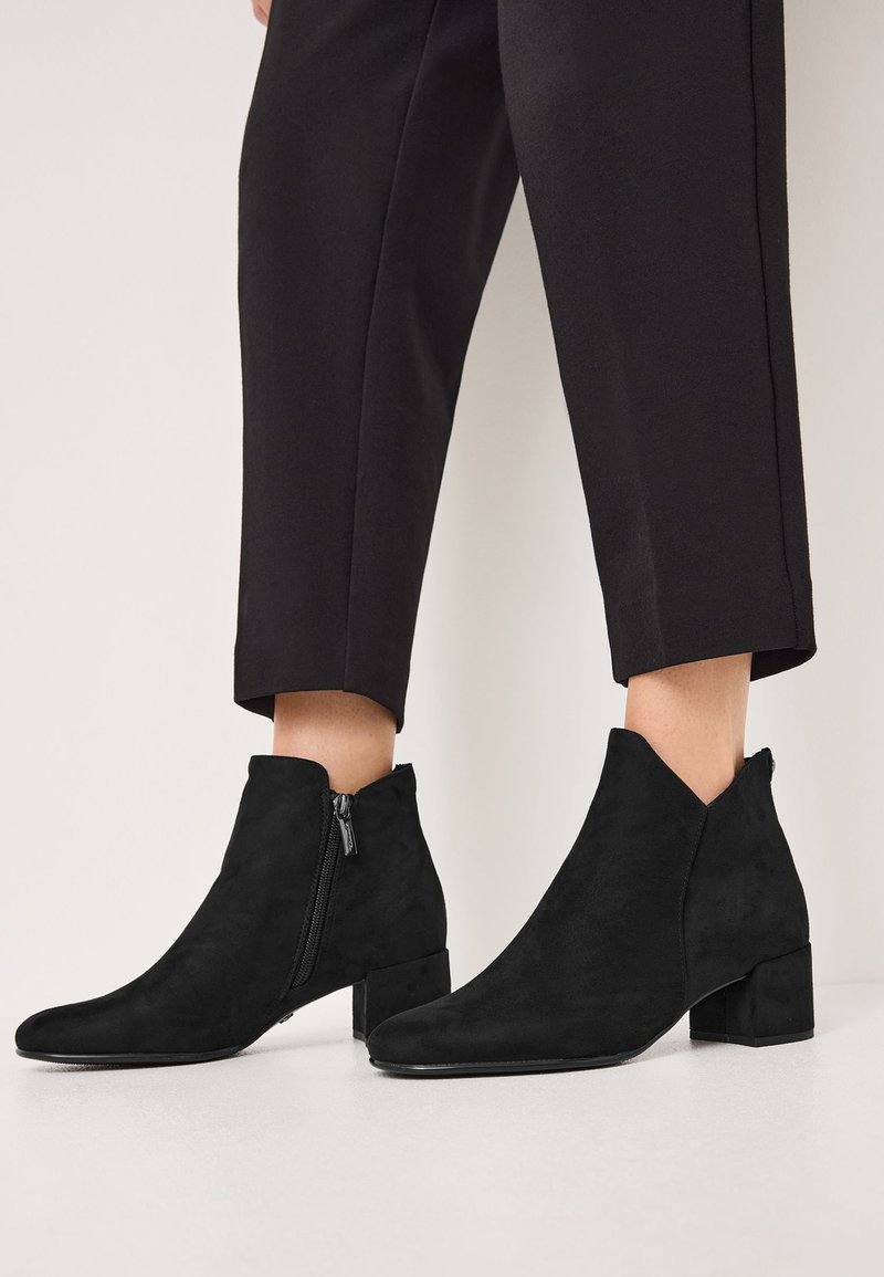 Black suede ankle boots with a pointed toe, low block heel, and side zipper. Smooth texture with a modern, minimalist design.