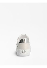 Sneaker bianco con una texture liscia, dotato di un retro metallico argento e un tallone in suede. Accentuato da un logo circolare sulla suola.