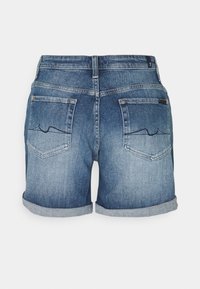 Pantalones cortos de mezclilla en azul claro con un efecto desgastado. Presentan puños enrollados, dos bolsillos traseros y un sutil detalle de costura.