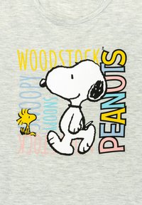 T-shirt in tessuto grigio con un'illustrazione a contorno nero di Snoopy che cammina con Woodstock. Il testo colorato reca le scritte "PEANUTS," "SNOOPY" e "WOODSTOCK."