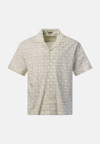 Chemise beige à manches courtes boutonnée avec motif carré à pois noirs et col cranté sur fond uni.