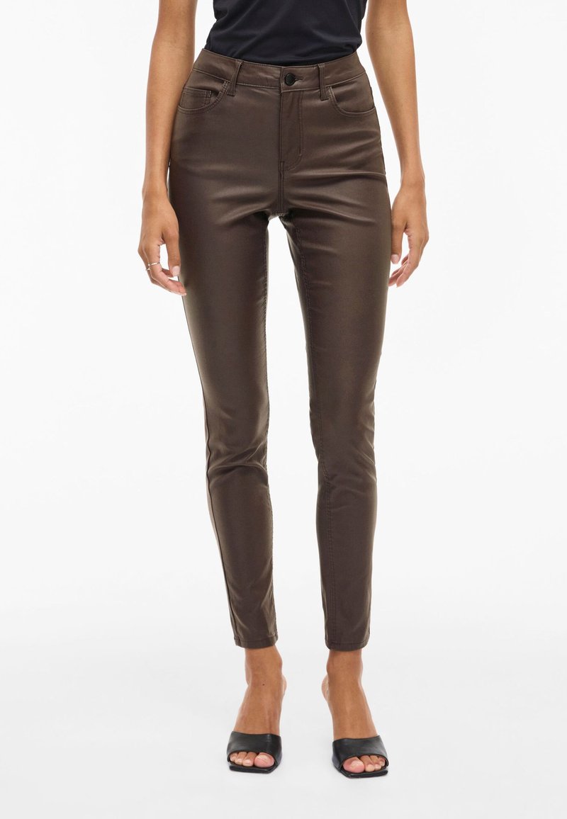 Hnědé skinny džíny s vysokým pasem z lesklého materiálu, s designem pěti kapes, zapínáním na knoflík a úzkým střihem, který se u kotníků zužuje.