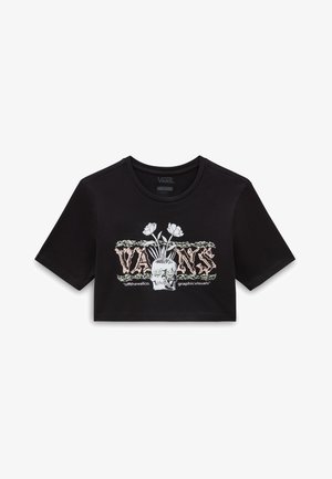 T-shirt cropped noir en coton avec un imprimé graphique représentant un crâne et des fleurs. Encolure ronde et manches courtes.