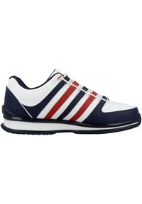 Sport shoe featuring a white, navy, and red design; synthetic material, low-cut shape, three distinctive red and white stripes, and textured accents.