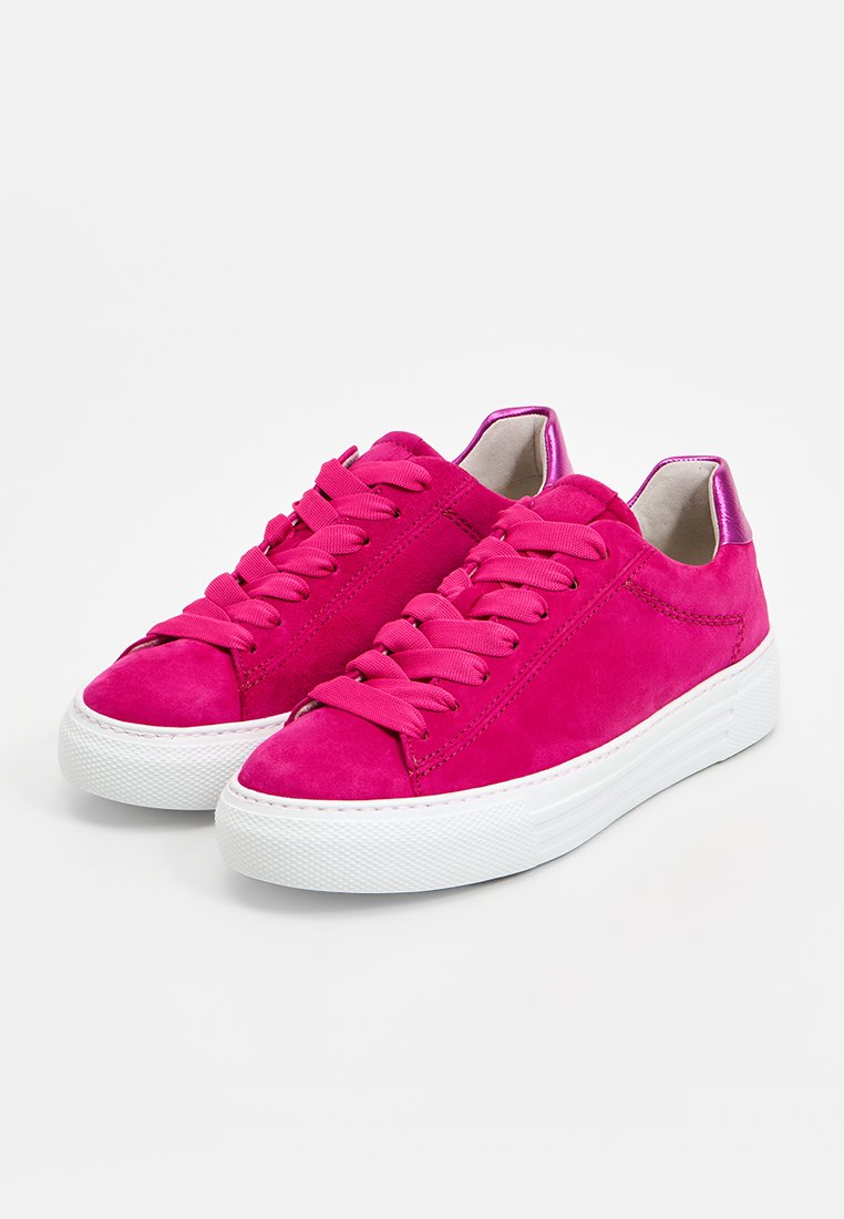 Helle rosa Wildledersneaker mit dicken weißen Gummisohlen, passenden rosa Schnürsenkeln und metallischen rosa Fersendetails, nebeneinander auf weißem Hintergrund dargestellt.