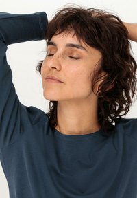 Marineblaues Langarmshirt mit lockerer Passform, Rundhalsausschnitt und weichem Material, das über die Ellenbogen hinausragende Bündchen hat.