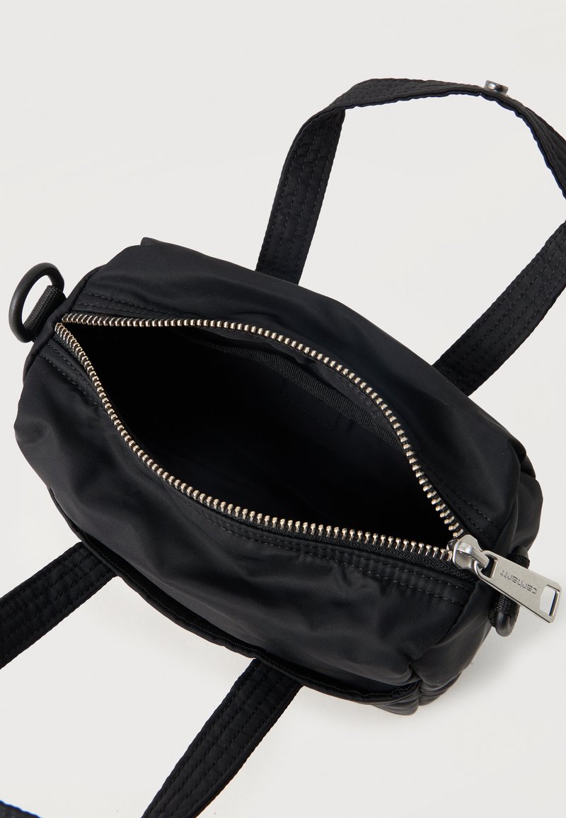 Borsa a tracolla in nylon nero con cerniera argento aperta, tracolla regolabile e cursore rettangolare in argento su sfondo bianco.