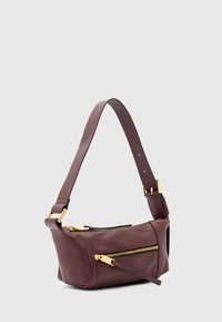 Bordeauxrode leren schoudertas met een gladde textuur, voorzien van ritssluitingen in goudkleur en een brede band. Compacte, hoekige vorm met twee vakken.