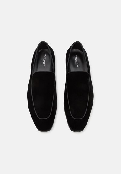 Schwarze Samt-Slipper mit flacher Sohle, runder Zehenpartie und einer dezenten kontrastierenden Borte entlang der Kante.