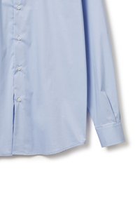 Camisa de manga larga azul claro con botones, hecha de tela suave, que presenta un cuello clásico, botones en la parte delantera y puños abotonados.