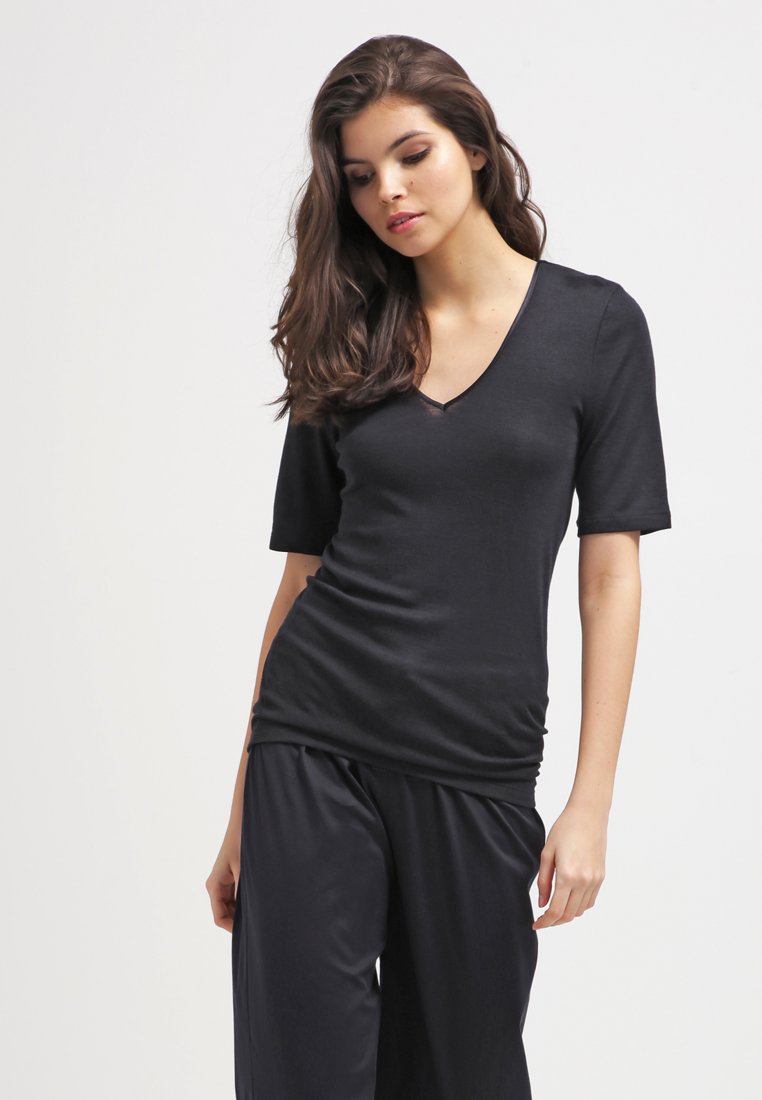 T-shirt nera a scollo a V con maniche corte, realizzata in un tessuto liscio e leggero. Design aderente con una lucentezza sottile e dettaglio arricciato in vita.