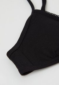 Czarny ribbed bralet z cienkimi ramiączkami i falbaniastym brzegiem. Gładka tekstura, dopasowany kształt i bez fiszbin.