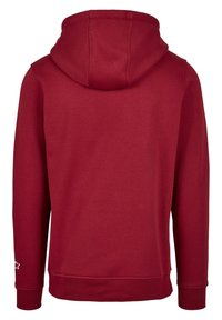 Sweat  à capuche rouge avec une poche kangourou à l'avant, une capuche à cordon de serrage ajustable, des poignets et un ourlet côtelés. Présente un petit logo étoile sur la manche.