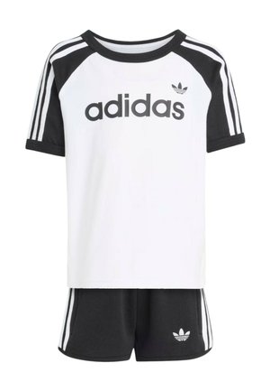 Maglietta Adidas a maniche corte bianca e nera con logo e pantaloncini neri abbinati con tre strisce bianche e logo trefoil Adidas.