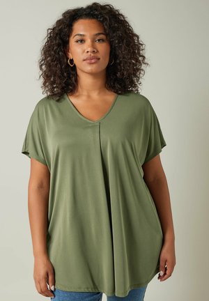 Top verde oliva con scollo a V e maniche corte. Realizzato in un tessuto morbido, presenta un design ampio e fluido con un dettaglio di cucitura centrale.